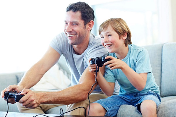 Image of Happy Son and Father Holding Joystick and Having Fun while playing games.